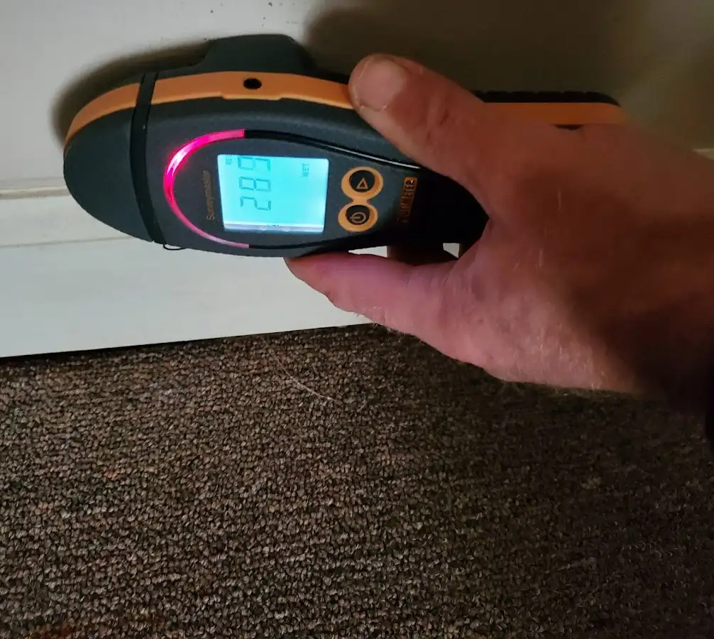 Moisture detection at baseboard during Storm Damage Restoration in Hays